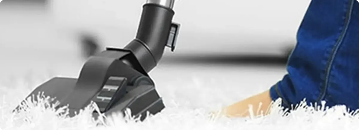 Close-up of a professional vacuuming a white carpet in Boonville.